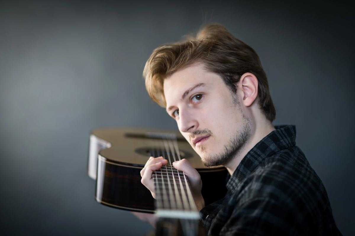 Dylan pointing his guitar at the camera